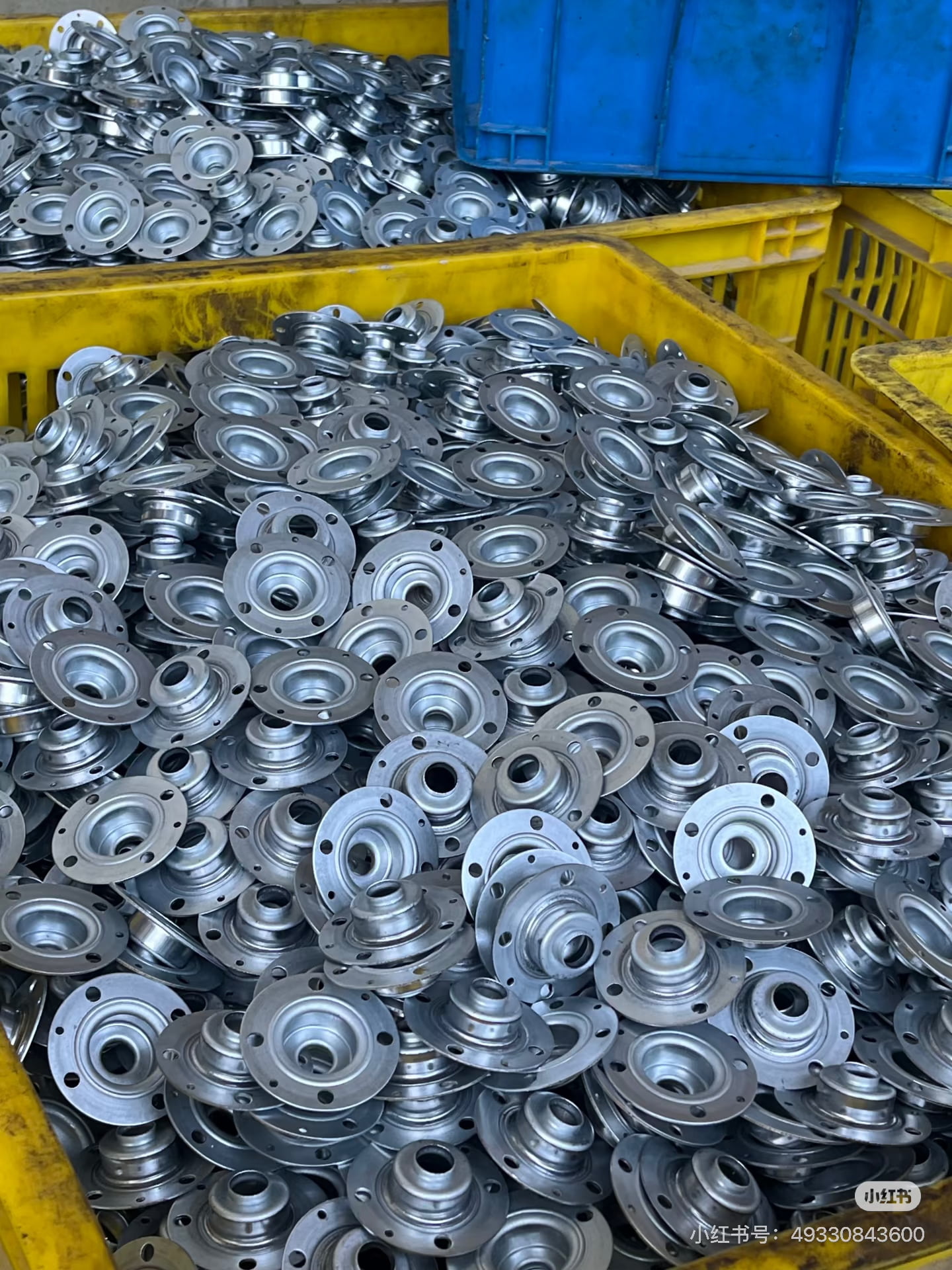 High-volume progressive die stamped metal parts in production bins